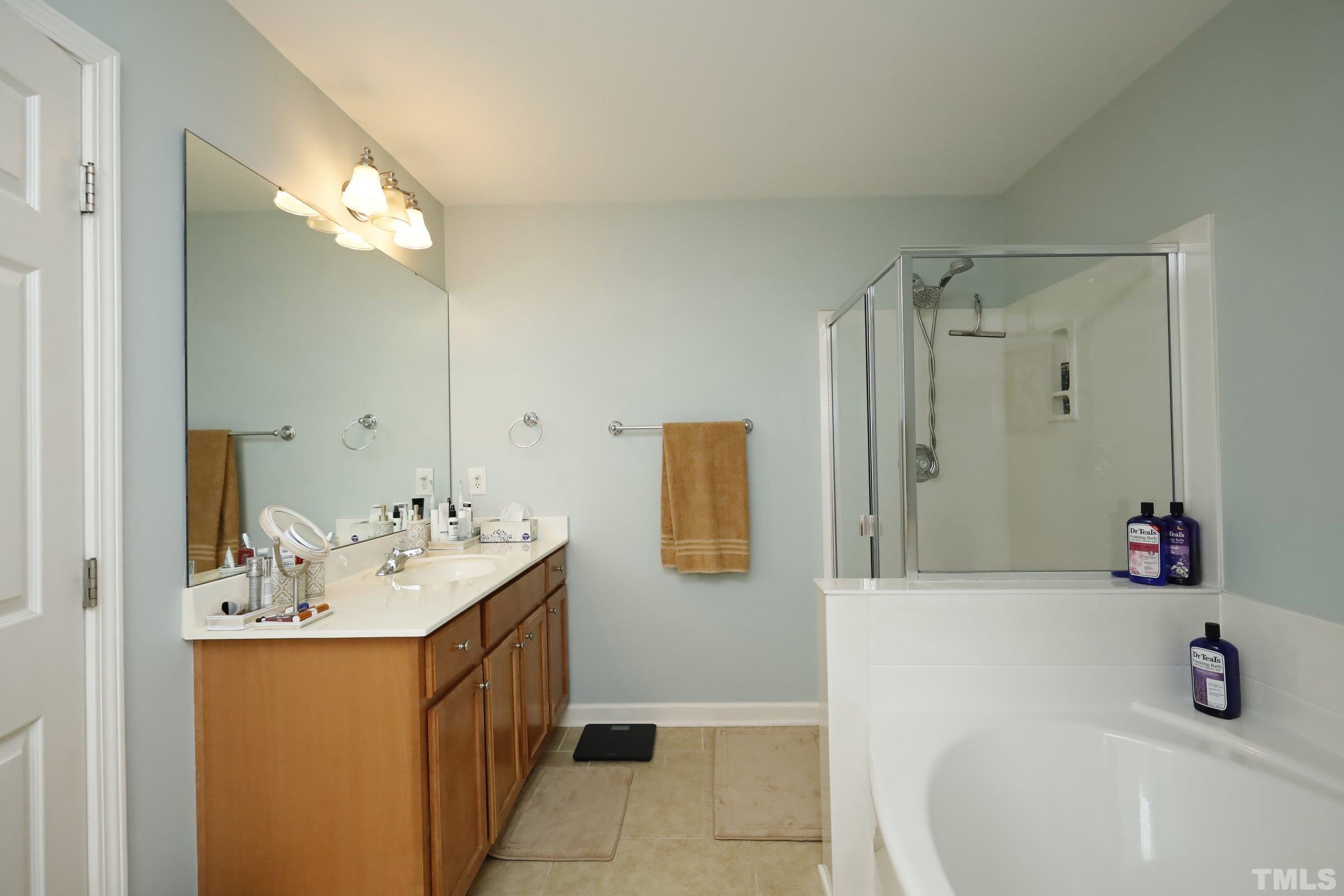 5325 Glass Ridge Road Raleigh, NC 27616 - Photo 25 of 42 a bathroom with a sink a tub and a mirror