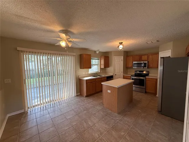 a kitchen with a refrigerator and a stove top oven
