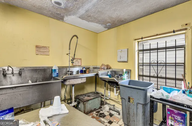 a living room with stainless steel appliances furniture and a flat screen tv