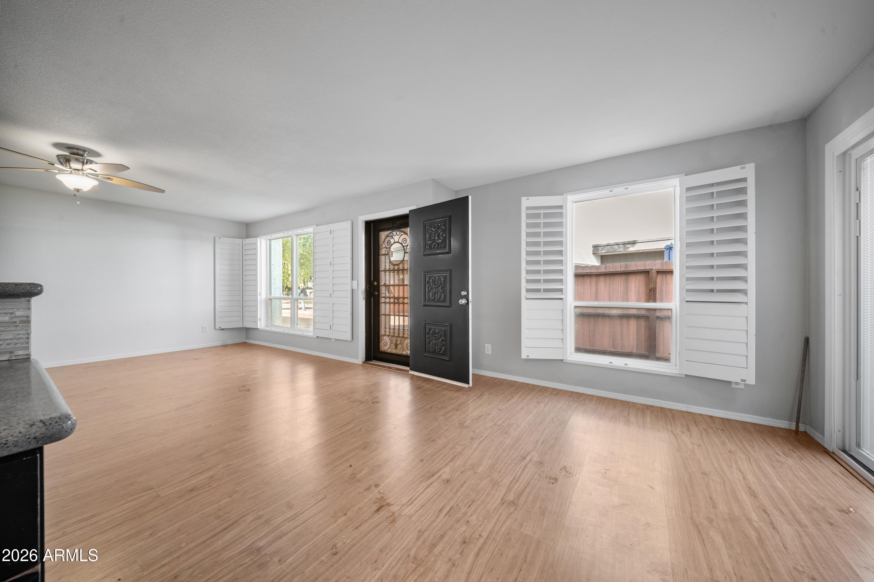 13230 North 3rd Way Phoenix, AZ 85022 - Photo 4 of 22 a view of an empty room with a window and wooden floor