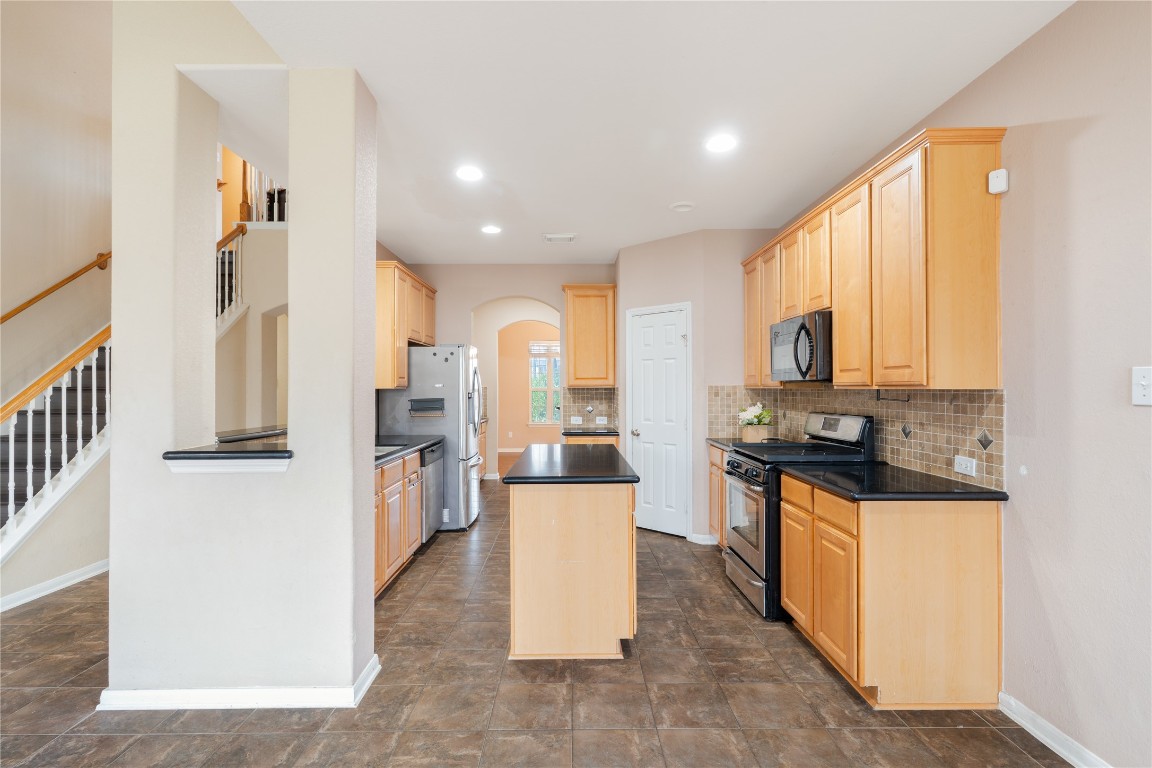 16622 Dover Mills Drive Spring, TX 77379 - Photo 6 of 20 a kitchen with stainless steel appliances granite countertop a stove top oven a sink a refrigerator and white cabinets with wooden floor