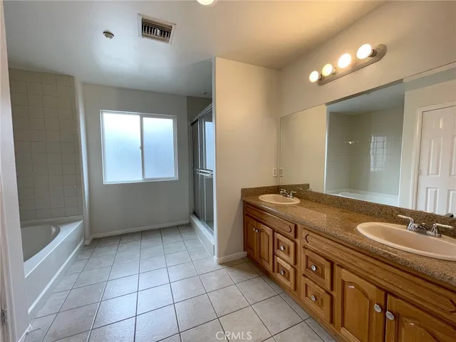 a spacious bathroom with a granite countertop sink a mirror and a bathtub