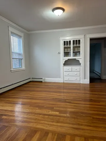 a view of empty room with wooden floor and cabinet