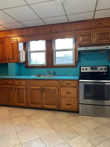 a kitchen with granite countertop a cabinets and a stove top oven