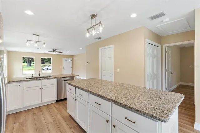 a bathroom with a granite countertop sink and white cabinets