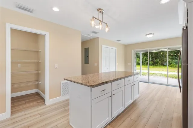 a large kitchen with a large window a counter space and stainless steel appliances