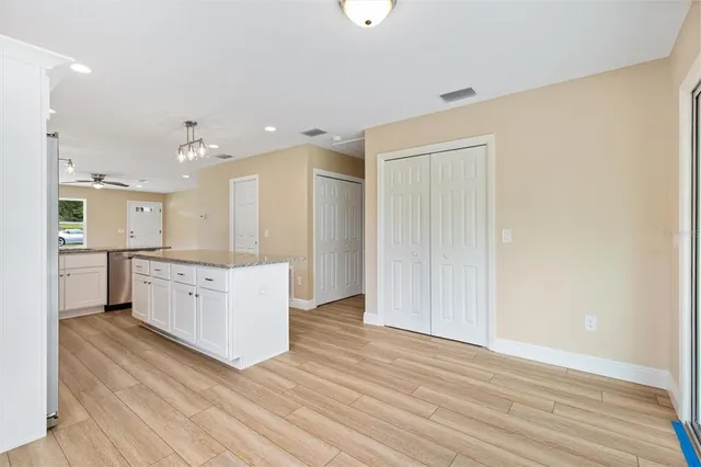 a large white kitchen with a white countertops a sink and a oven