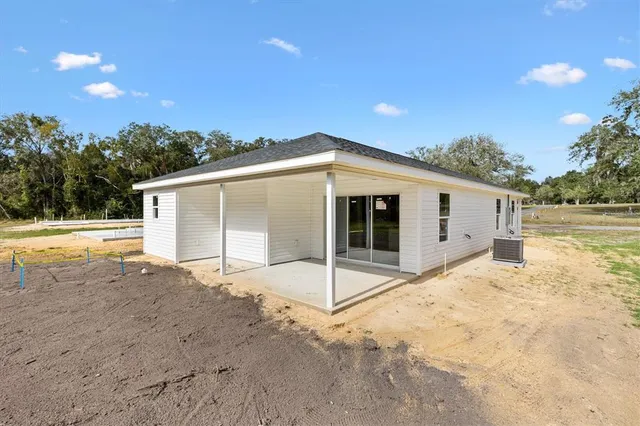 a view of a house with backyard and trees
