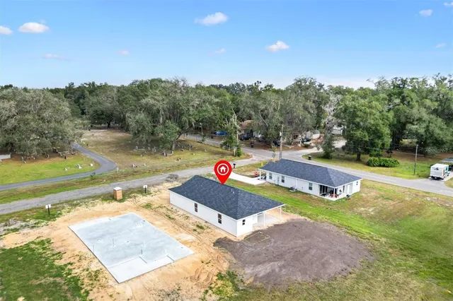 a view of yard with swimming pool and trees in the background
