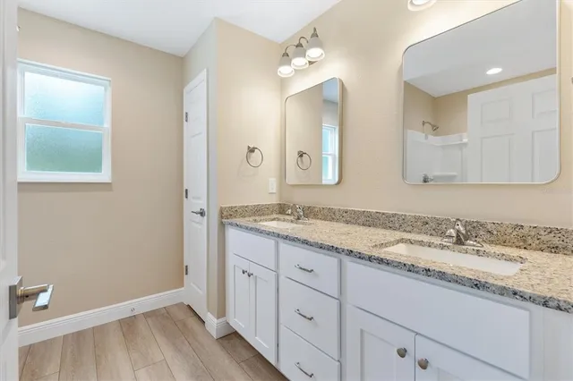 a bathroom with a granite countertop sink mirror and double