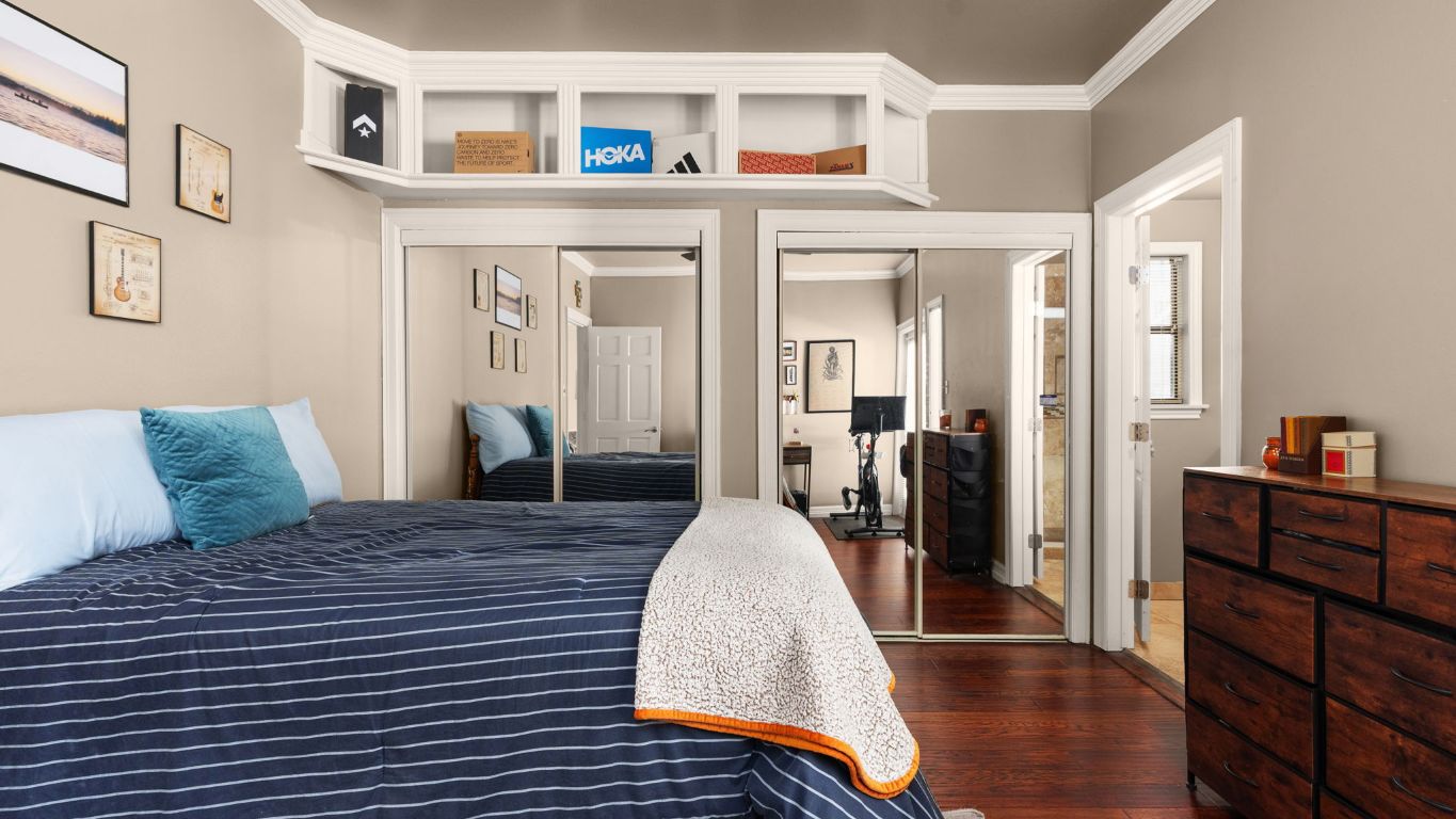 807 West 25th Street, Unit 207 Austin, TX 78705 - Photo 13 of 25 a large bedroom with a bed and wooden floor