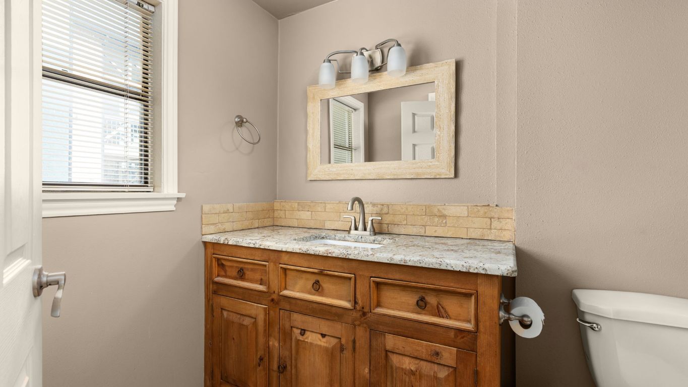 807 West 25th Street, Unit 207 Austin, TX 78705 - Photo 14 of 25 a bathroom with a granite countertop toilet sink and mirror