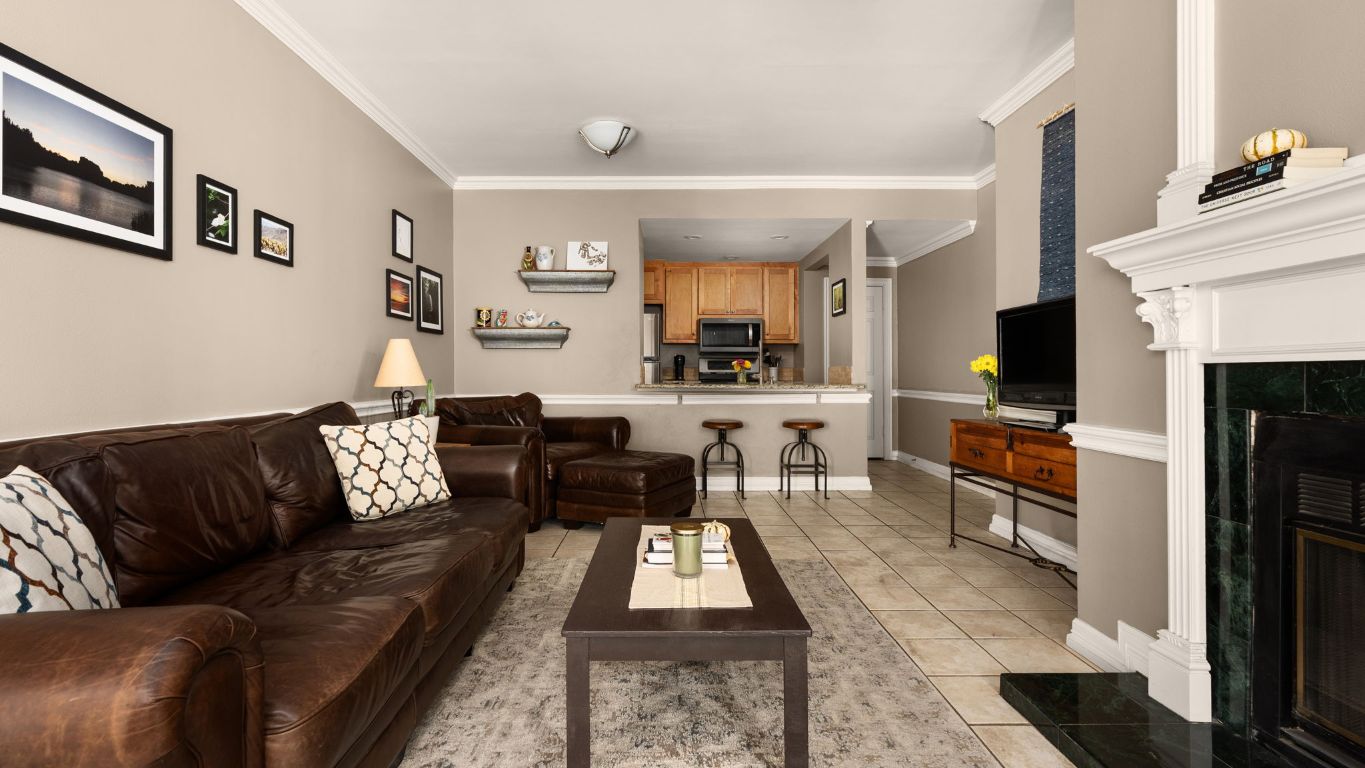 807 West 25th Street, Unit 207 Austin, TX 78705 - Photo 2 of 25 a living room with furniture a flat screen tv and a fireplace