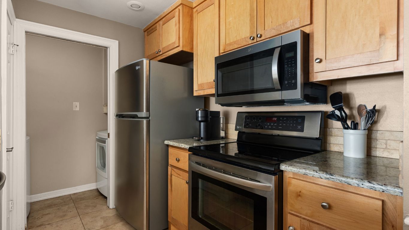 807 West 25th Street, Unit 207 Austin, TX 78705 - Photo 7 of 25 a kitchen with stainless steel appliances granite countertop a stove microwave and refrigerator