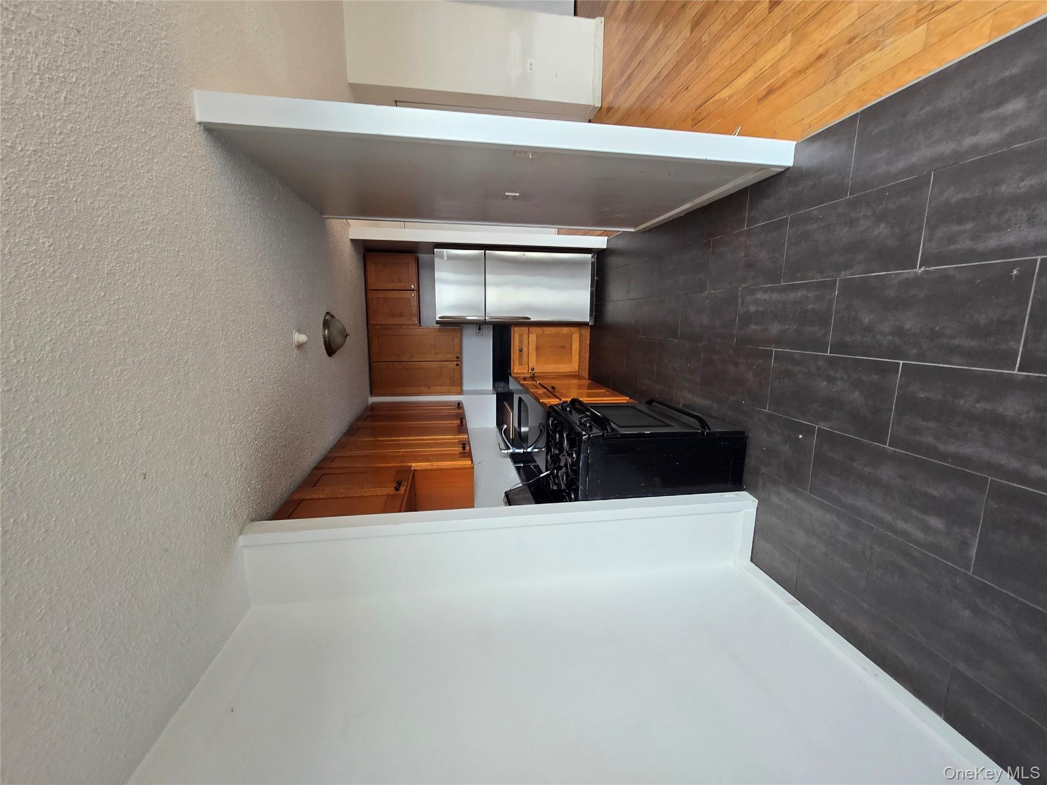 34-12 113th Street, Unit 9B Queens, NY 11368 - Photo 3 of 7 a kitchen with a refrigerator and a stove top oven