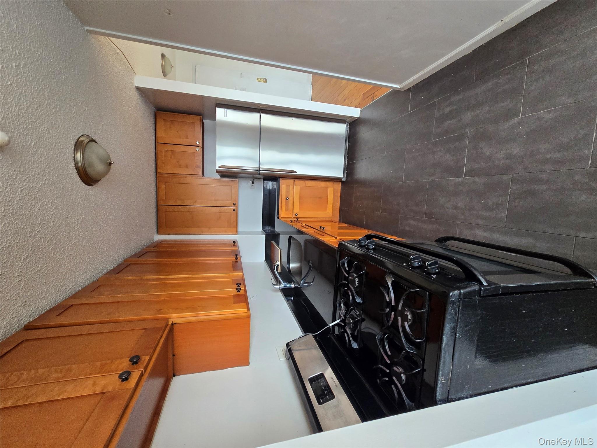 34-12 113th Street, Unit 9B Queens, NY 11368 - Photo 4 of 7 a kitchen with a stove and a refrigerator