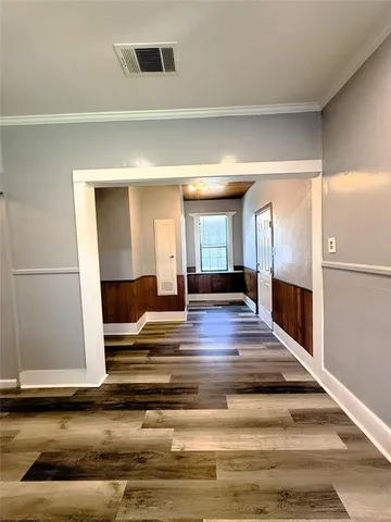 a bedroom with a bed and wooden floors