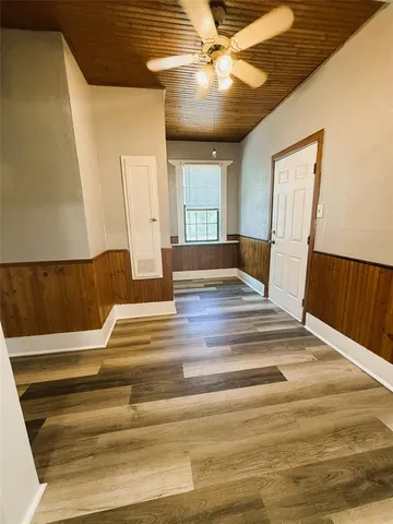 a view of a hallway with wooden floor and staircase