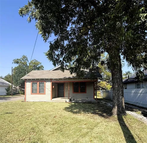 a view of a yard with a house and large tree