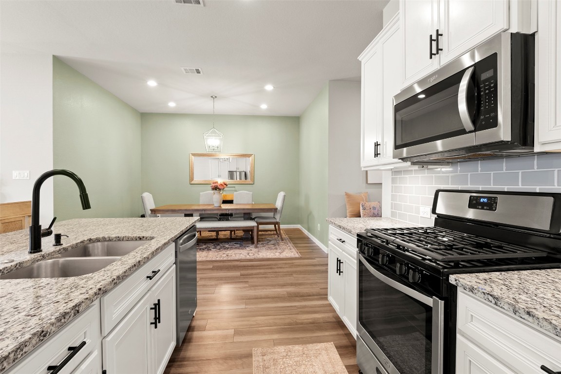 14239 Volcano Perch Drive Conroe, TX 77384 - Photo 14 of 39 a kitchen with stainless steel appliances granite countertop a stove a sink and a microwave