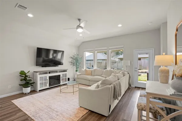 a living room with furniture a flat screen tv and a fireplace