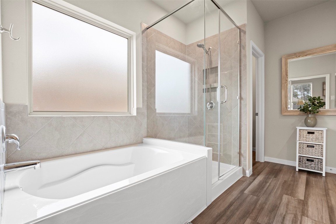 14239 Volcano Perch Drive Conroe, TX 77384 - Photo 21 of 39 An oversized soaking tub with privacy glass window, a separate shower with seamless glass...and notice the durable luxury vinyl plank flooring this this area as well.