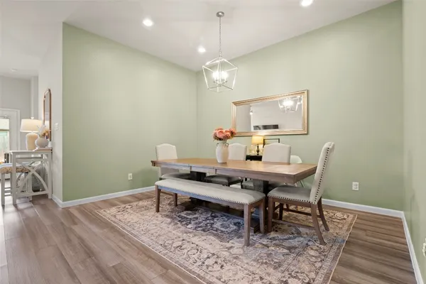 a kitchen with stainless steel appliances a refrigerator a stove a sink a dining table and chairs