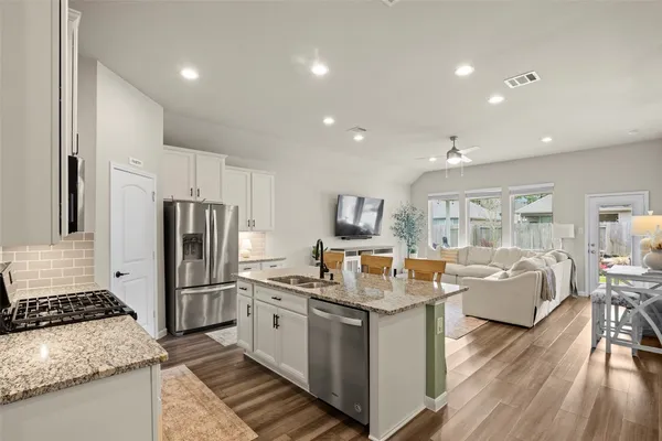 a kitchen with stainless steel appliances granite countertop a stove a sink and a microwave