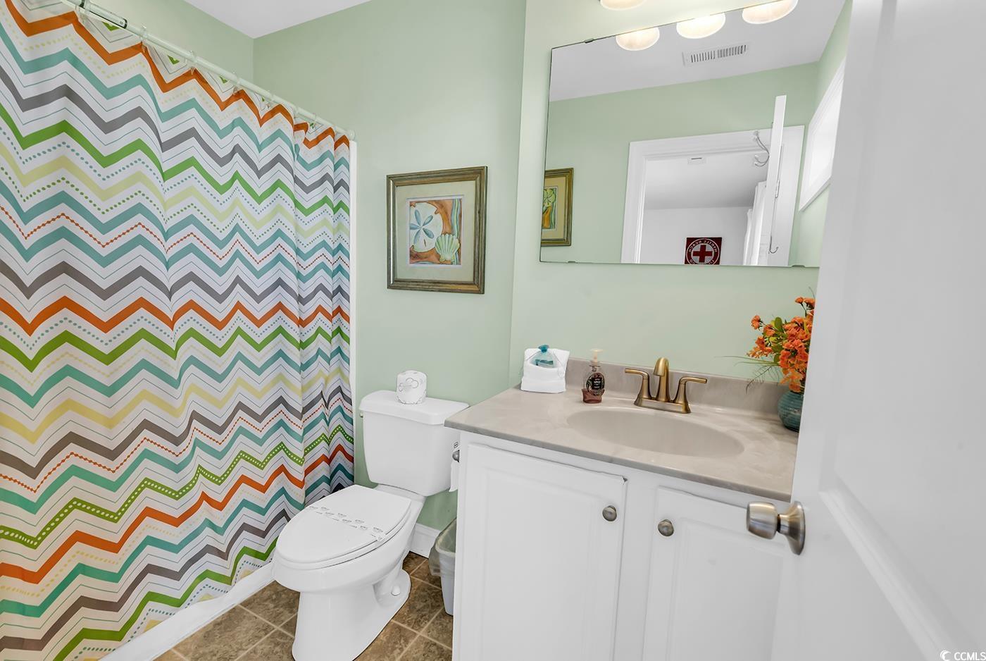 124 B Vista Drive Murrells Inlet, SC 29576 - Photo 24 of 38 Bathroom featuring vanity, curtained shower, and dark tile patterned floors