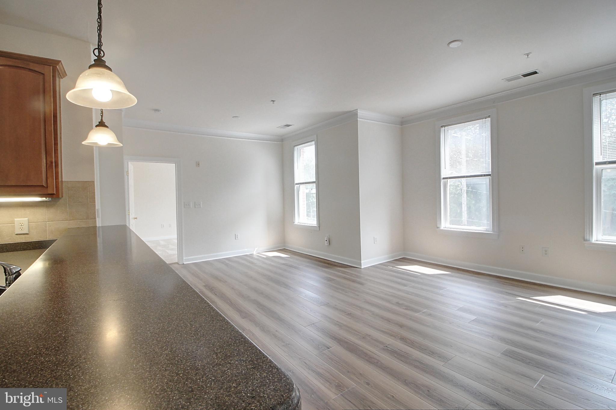 35 East All Saints Street, Unit 321 Frederick, MD 21701 - Photo 4 of 17 a view of an empty room with window and wooden floor
