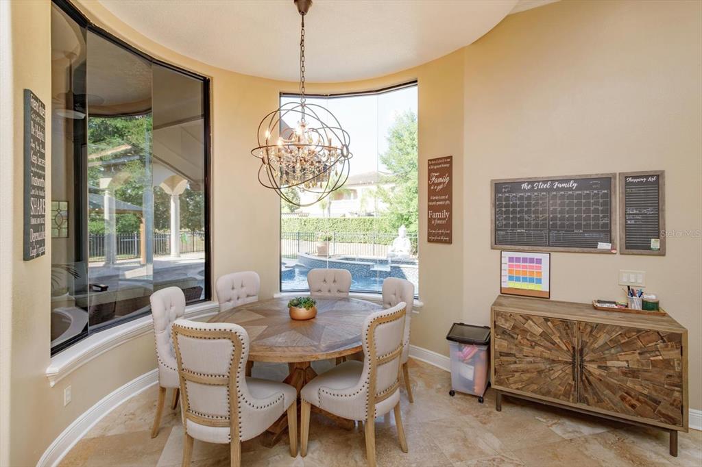 5719 Emerson Pointe Way Orlando, FL 32819 - Photo 11 of 50 a dining room with furniture a chandelier and window
