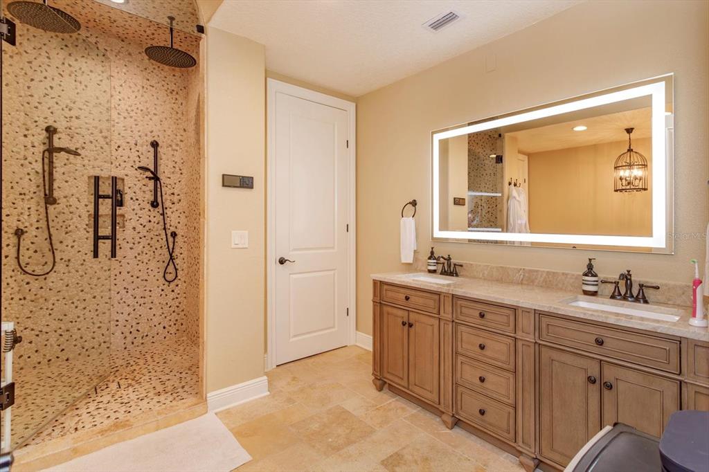 5719 Emerson Pointe Way Orlando, FL 32819 - Photo 21 of 50 a spacious bathroom with a double vanity sink mirror and shower