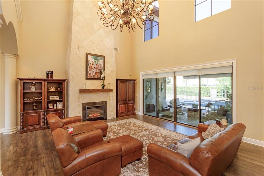 5719 Emerson Pointe Way Orlando, FL 32819 - Photo 3 of 50 a living room with furniture a fireplace and a flat screen tv