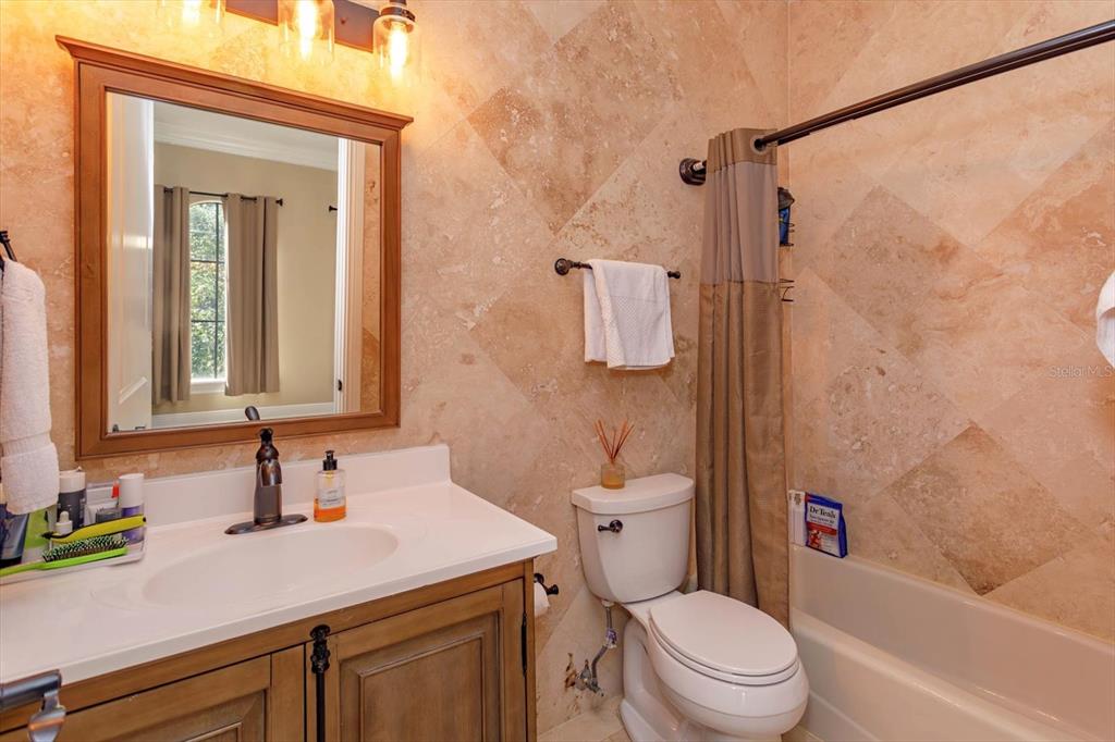 5719 Emerson Pointe Way Orlando, FL 32819 - Photo 36 of 50 a bathroom with a sink a toilet and shower