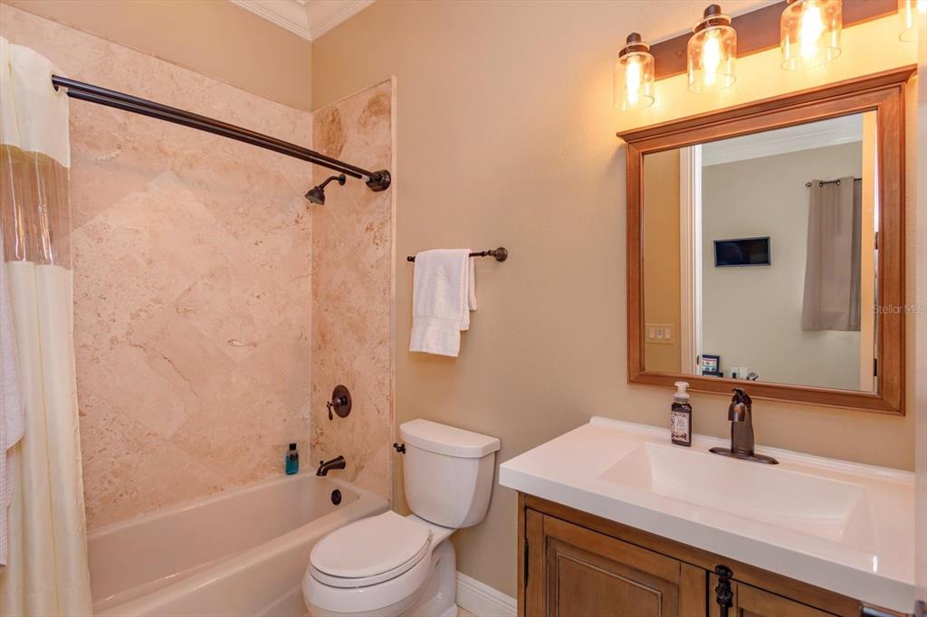 5719 Emerson Pointe Way Orlando, FL 32819 - Photo 39 of 50 a bathroom with a sink a toilet a mirror and shower