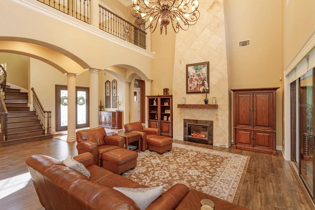 5719 Emerson Pointe Way Orlando, FL 32819 - Photo 5 of 50 a living room with furniture a fireplace and a flat screen tv