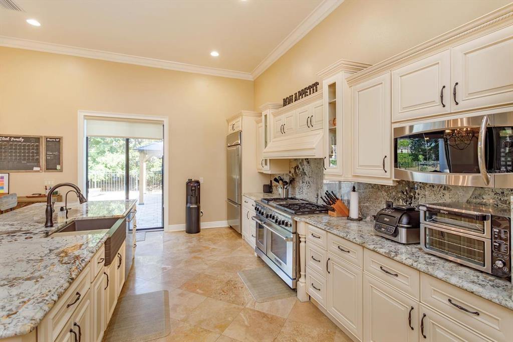5719 Emerson Pointe Way Orlando, FL 32819 - Photo 9 of 50 a kitchen with stainless steel appliances granite countertop a sink stove and cabinets