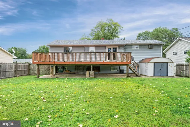 a backyard of a house with large trees and plants