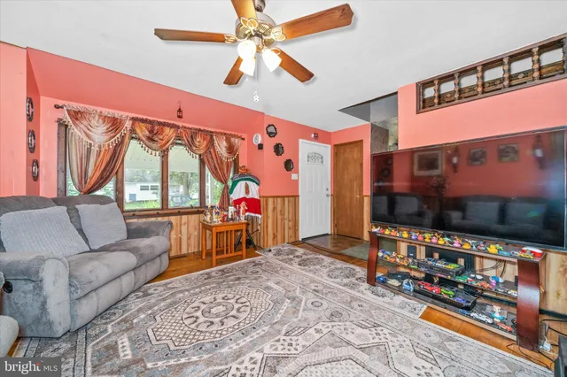 a living room with furniture a flat screen tv and a floor to ceiling window