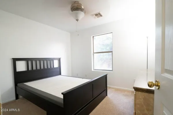 a large bed sitting in a bedroom next to a window