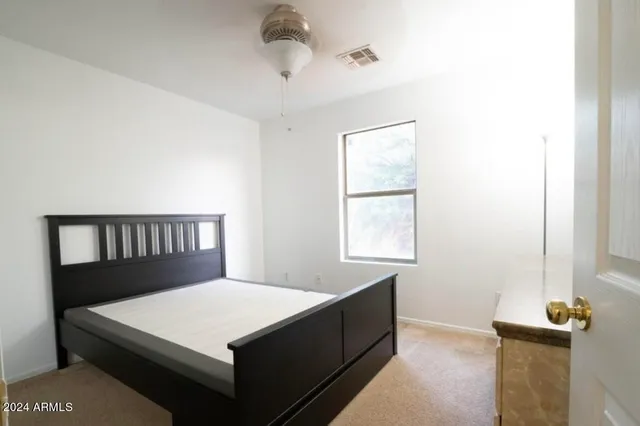 a large bed sitting in a bedroom next to a window