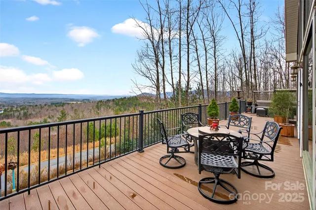 a view of a roof deck with table and chairs and wooden floor