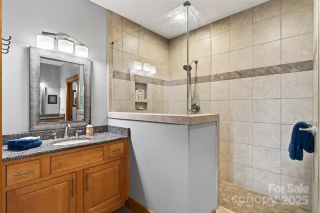 a bathroom with a double vanity sink a mirror and a shower