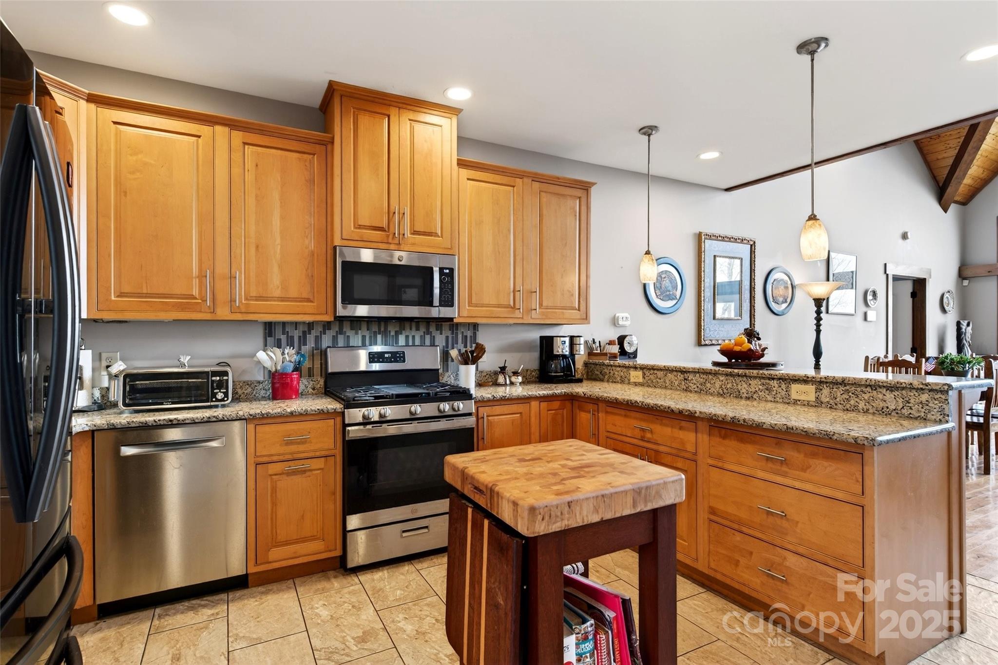 242 Lakeview Trail Nebo, NC 28761 - Photo 10 of 46 a kitchen with stainless steel appliances granite countertop a stove top oven a sink dishwasher a dining table and chairs with wooden floor