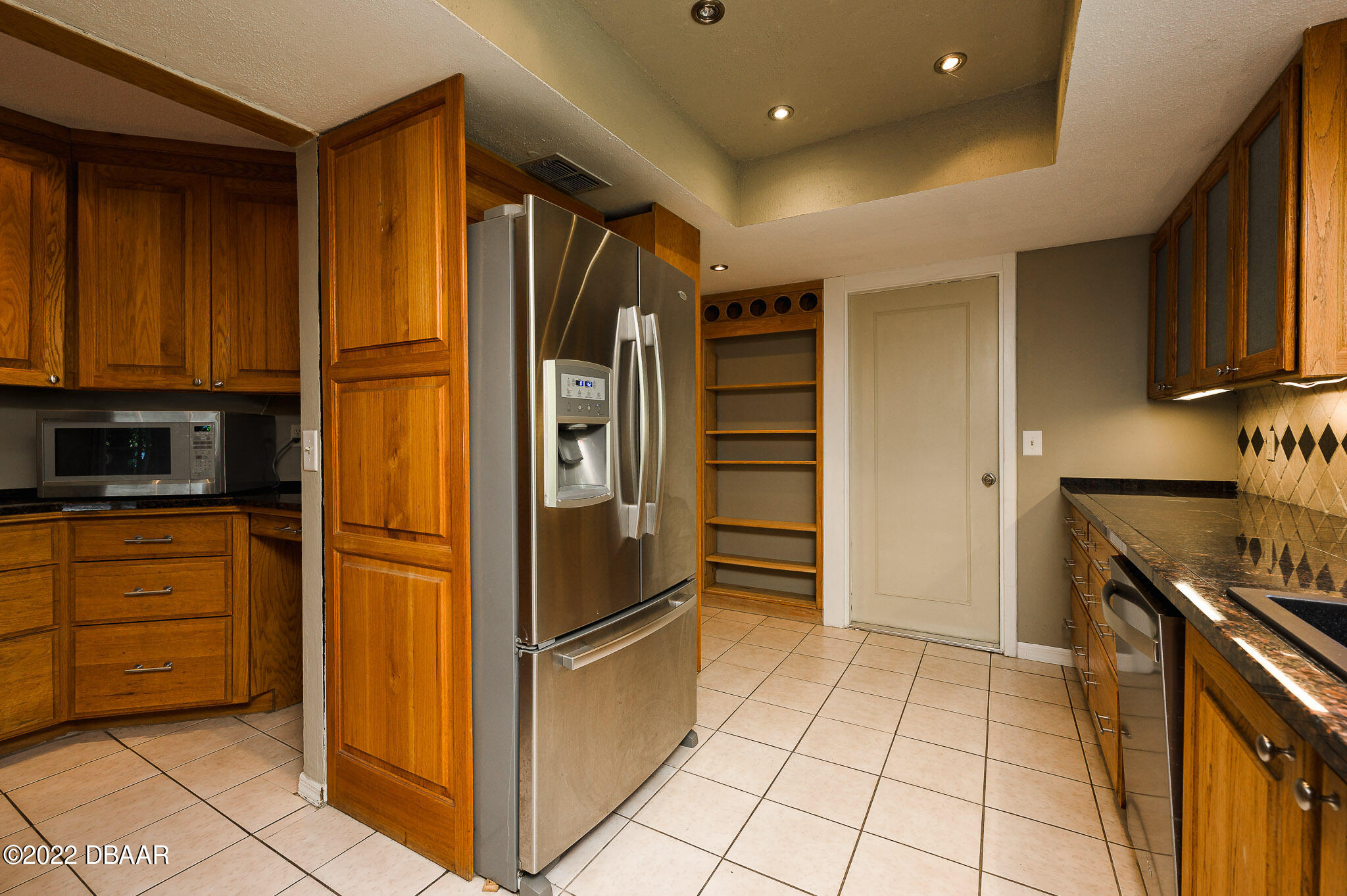 35 Pebble Beach Drive Ormond Beach, FL 32174 - Photo 15 of 45 a kitchen with granite countertop a refrigerator and a stove top oven