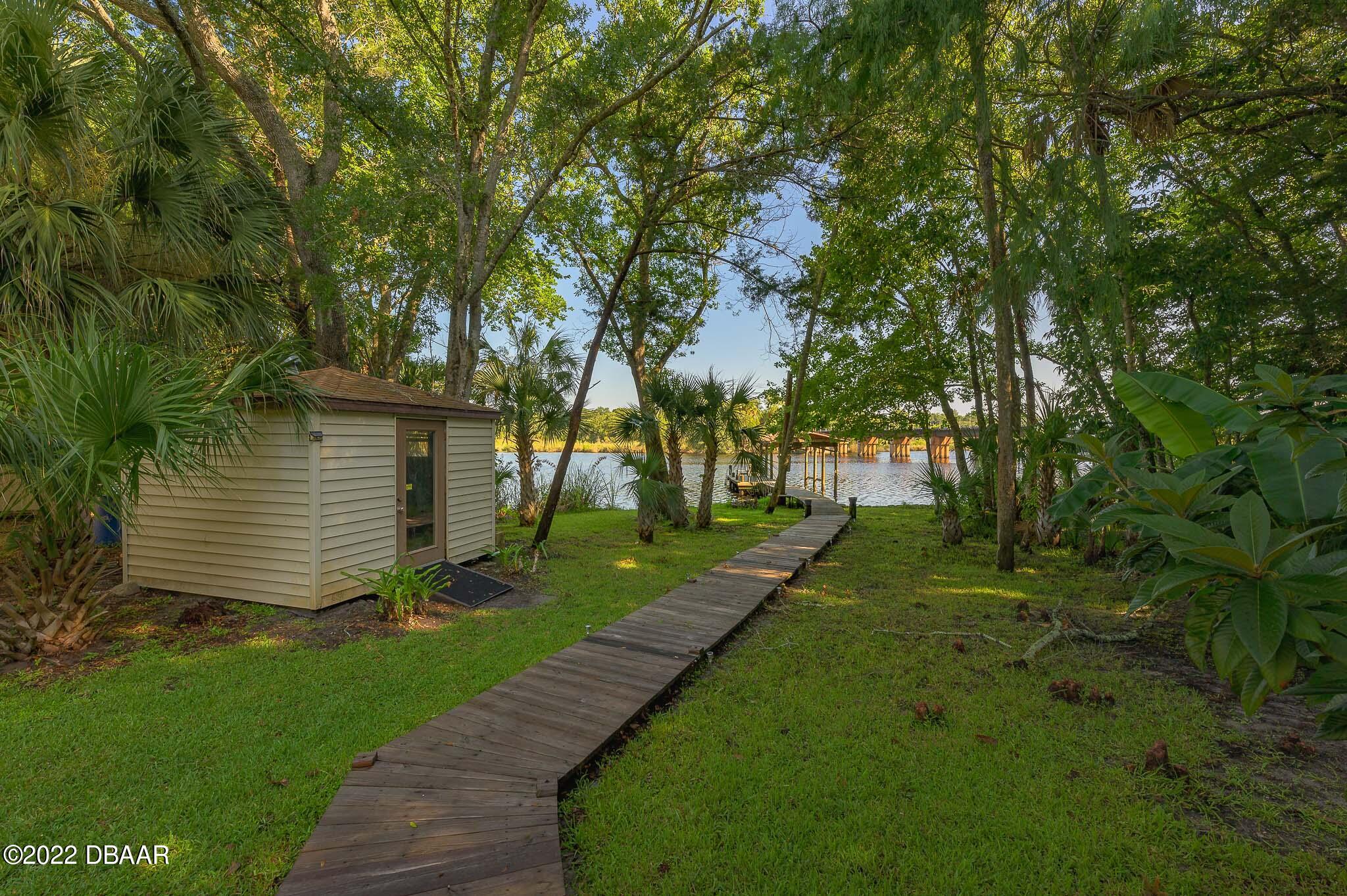 35 Pebble Beach Drive Ormond Beach, FL 32174 - Photo 34 of 45 a view of a backyard with plants and a large tree