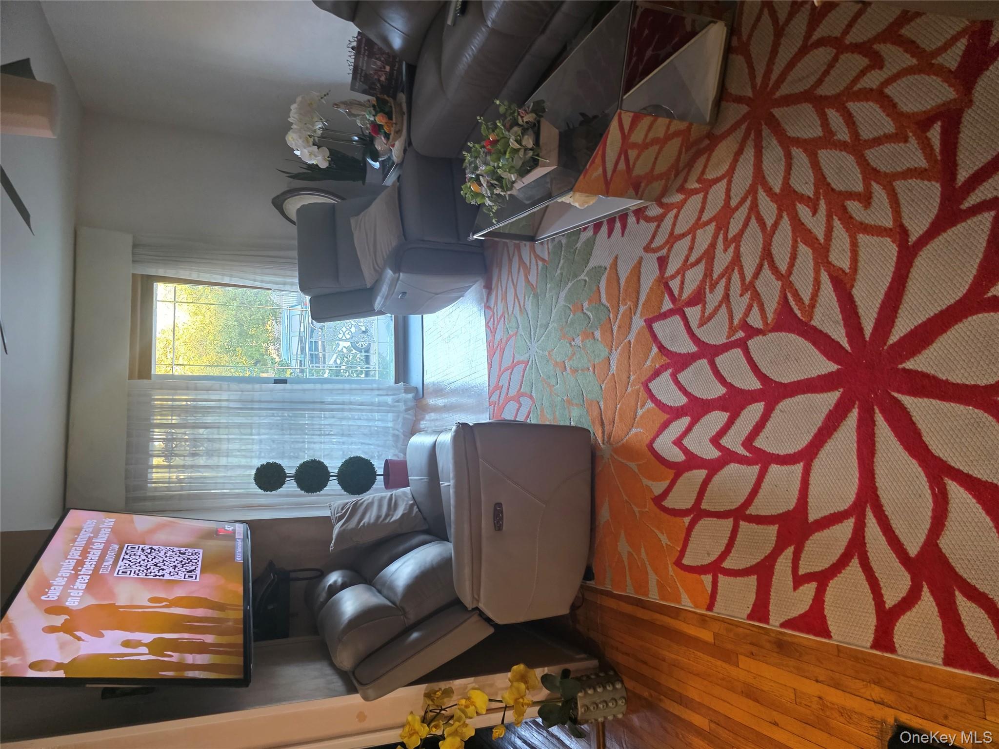 49-12 111th Street Queens, NY 11368 - Photo 3 of 9 a living room with furniture and a flat screen tv