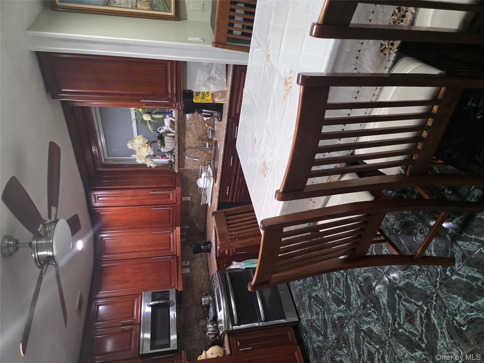 49-12 111th Street Queens, NY 11368 - Photo 6 of 9 a kitchen with stainless steel appliances kitchen island granite countertop a stove a sink a microwave and island