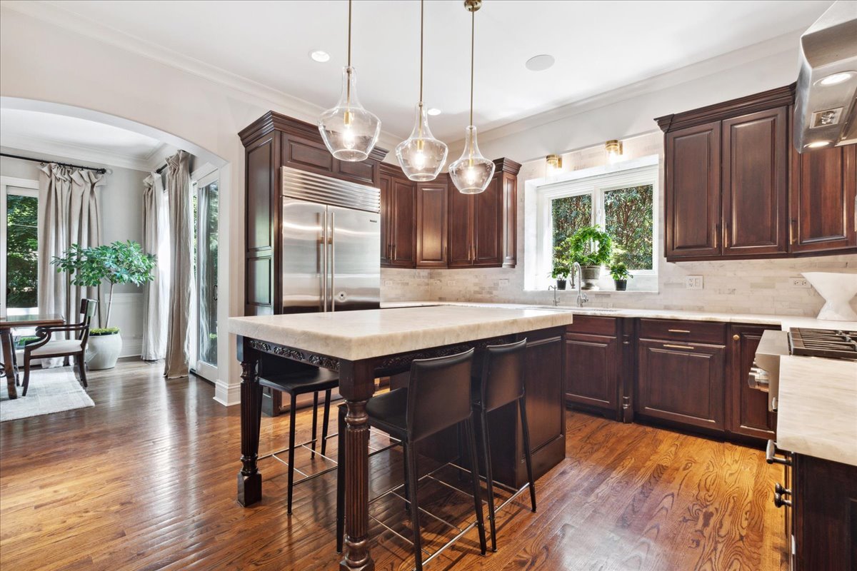 811 Lenox Road Glenview, IL 60025 - Photo 4 of 27 a kitchen with a table chairs and wooden cabinets