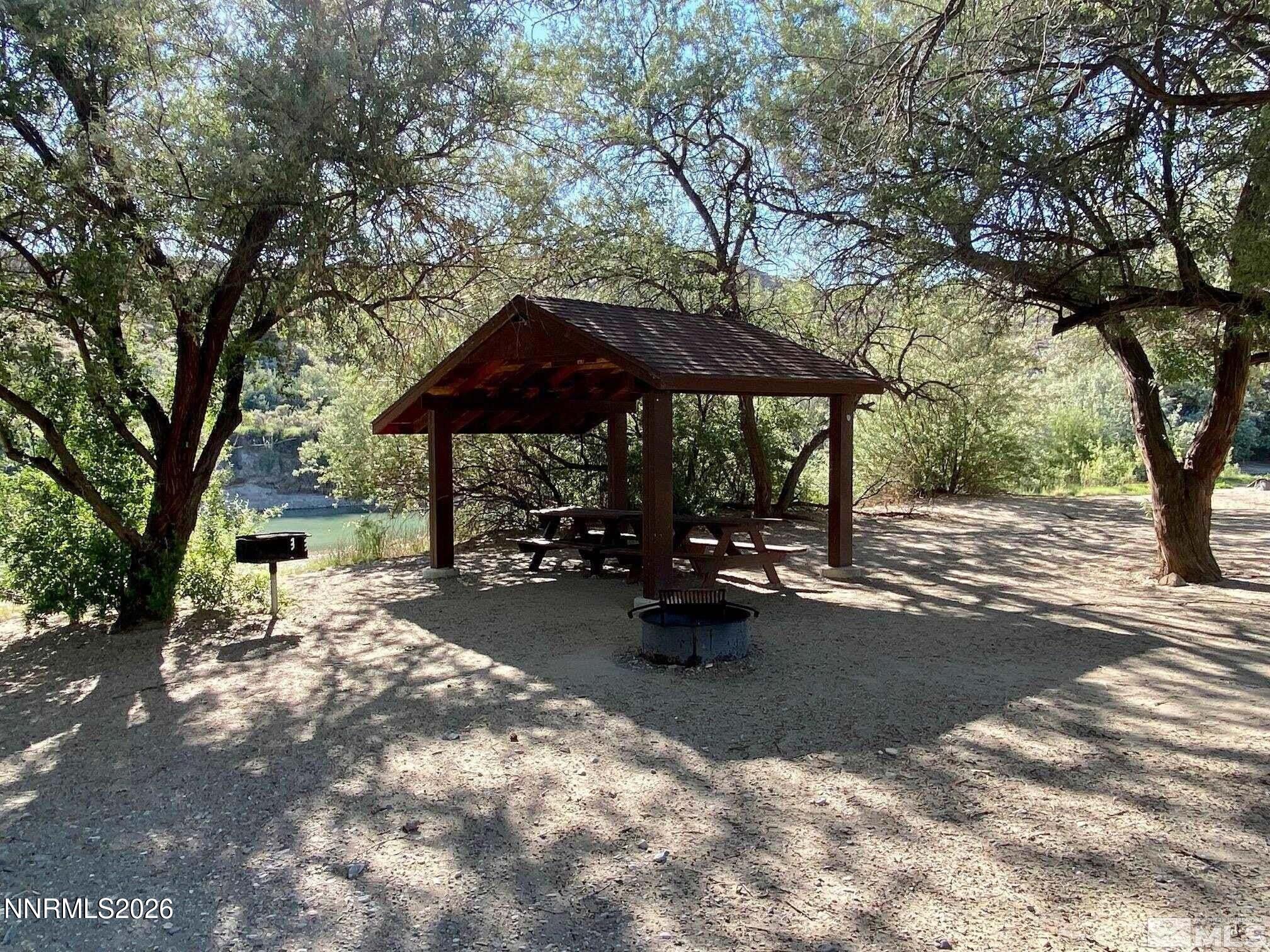 11385 Union Valley Road Lovelock, NV 89419 - Photo 7 of 17 a view of a patio with table and chairs under an umbrella with large trees